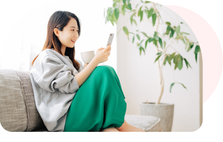 ソファでスマホを見る女性